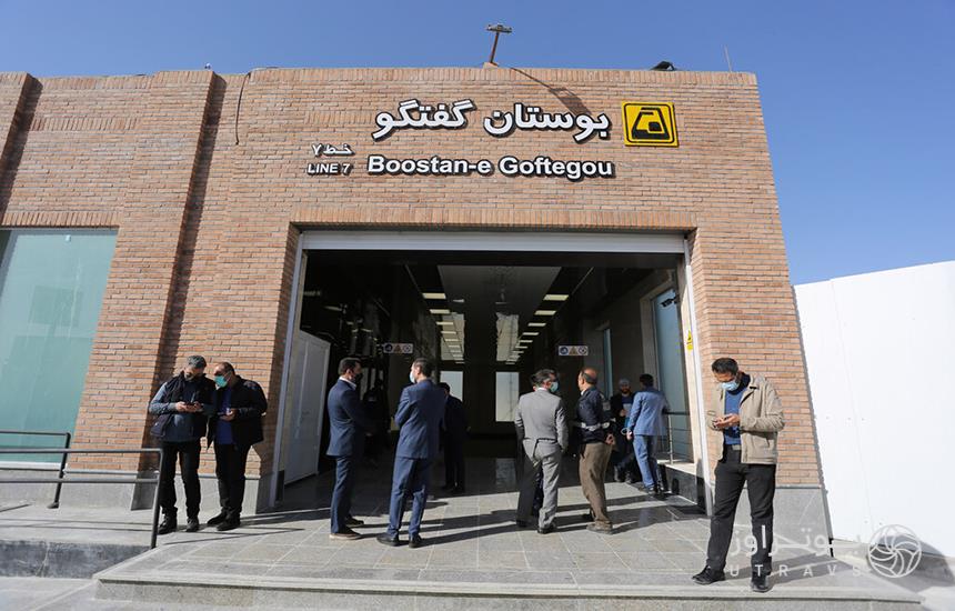 ورودی ایستگاه «بوستان گفت‌وگو» در خط 7 مترو تهران که سردری آجری دارد و چند مرد جلوی آن ایستاده‌اند.